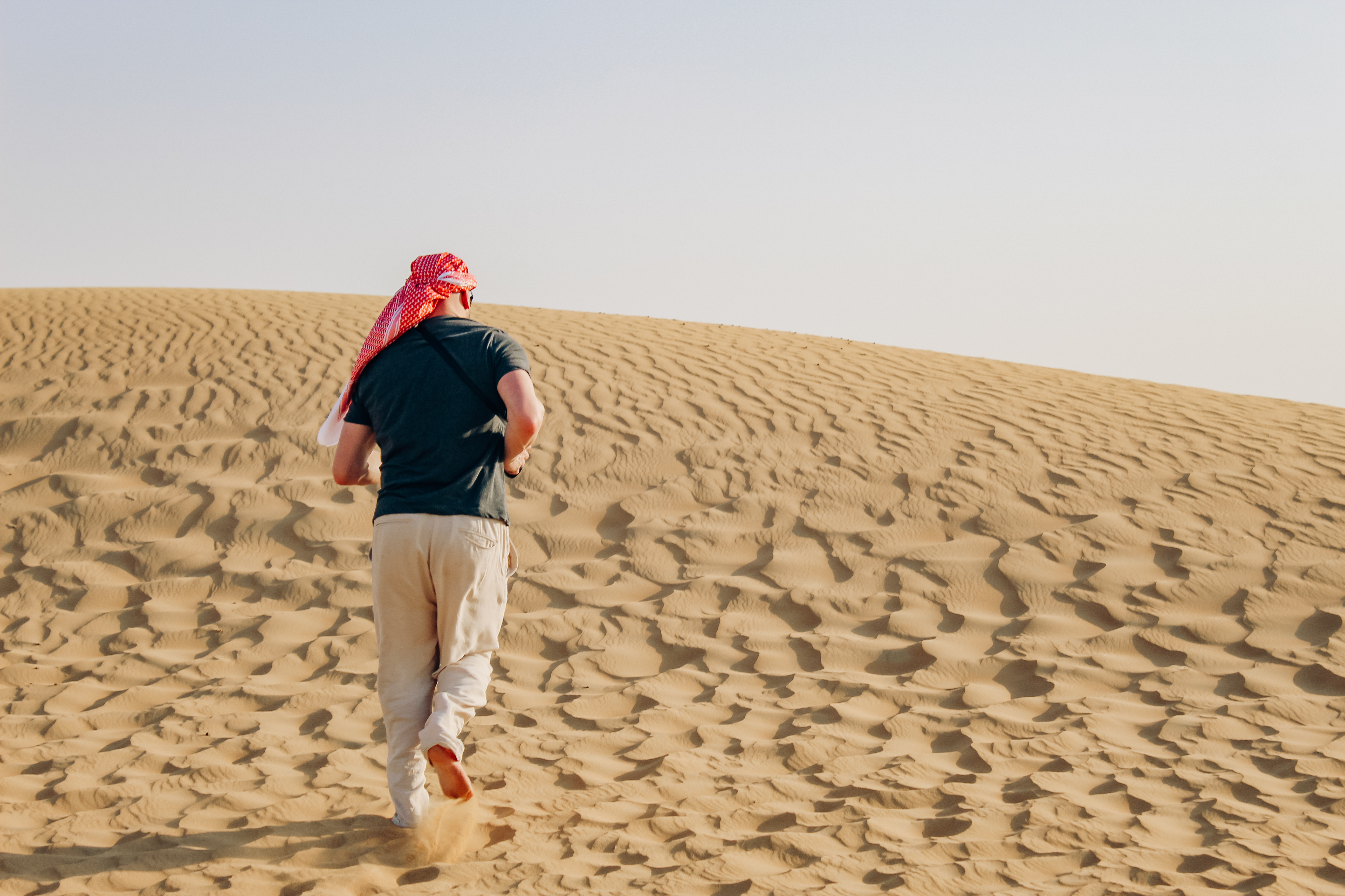 Man running up sand dune